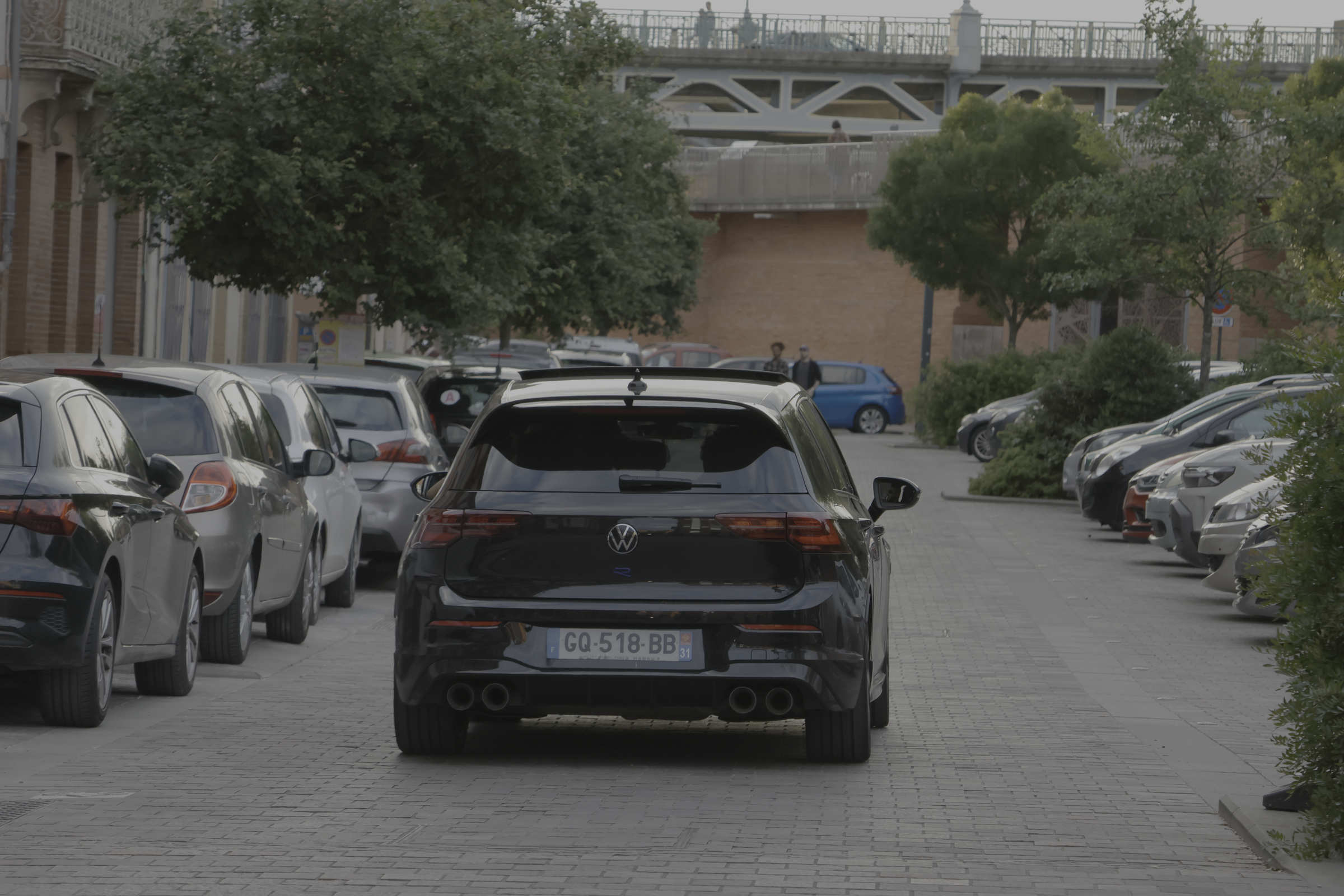 Vue arrière d’une berline noire dans une rue urbaine