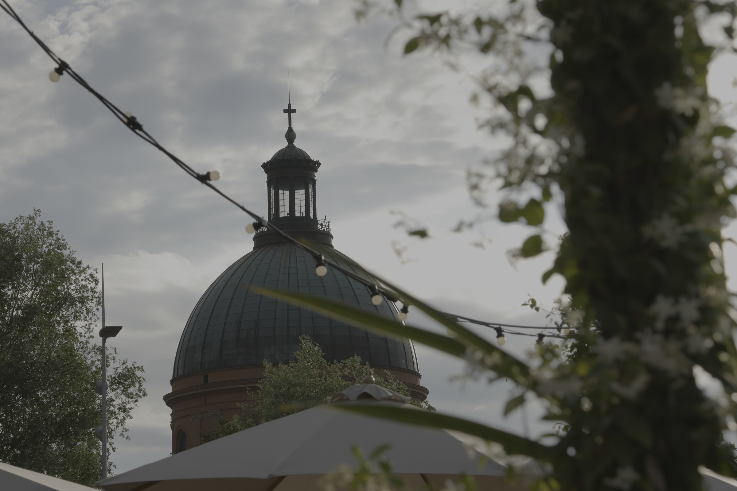 Coupole et lampadaire entre les feuillages sous un ciel gris