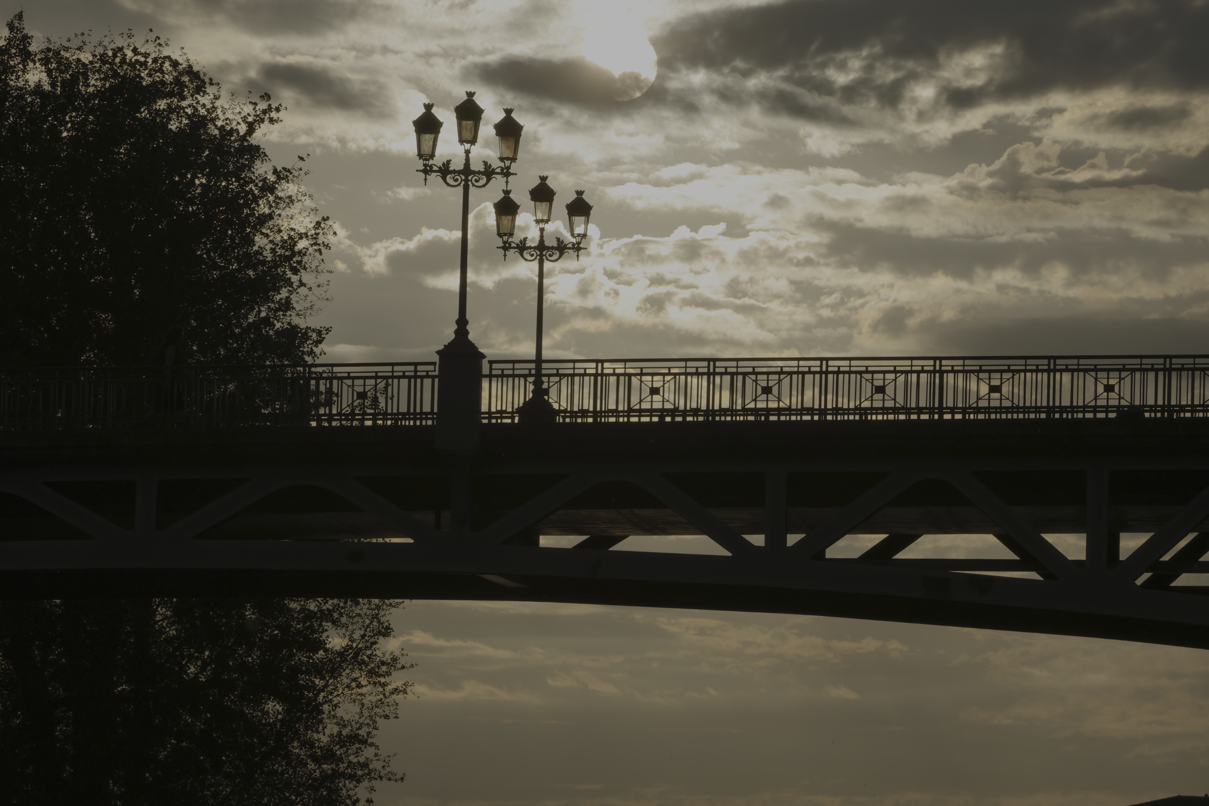 Pont et lampadaire en silhouette devant le ciel du soir