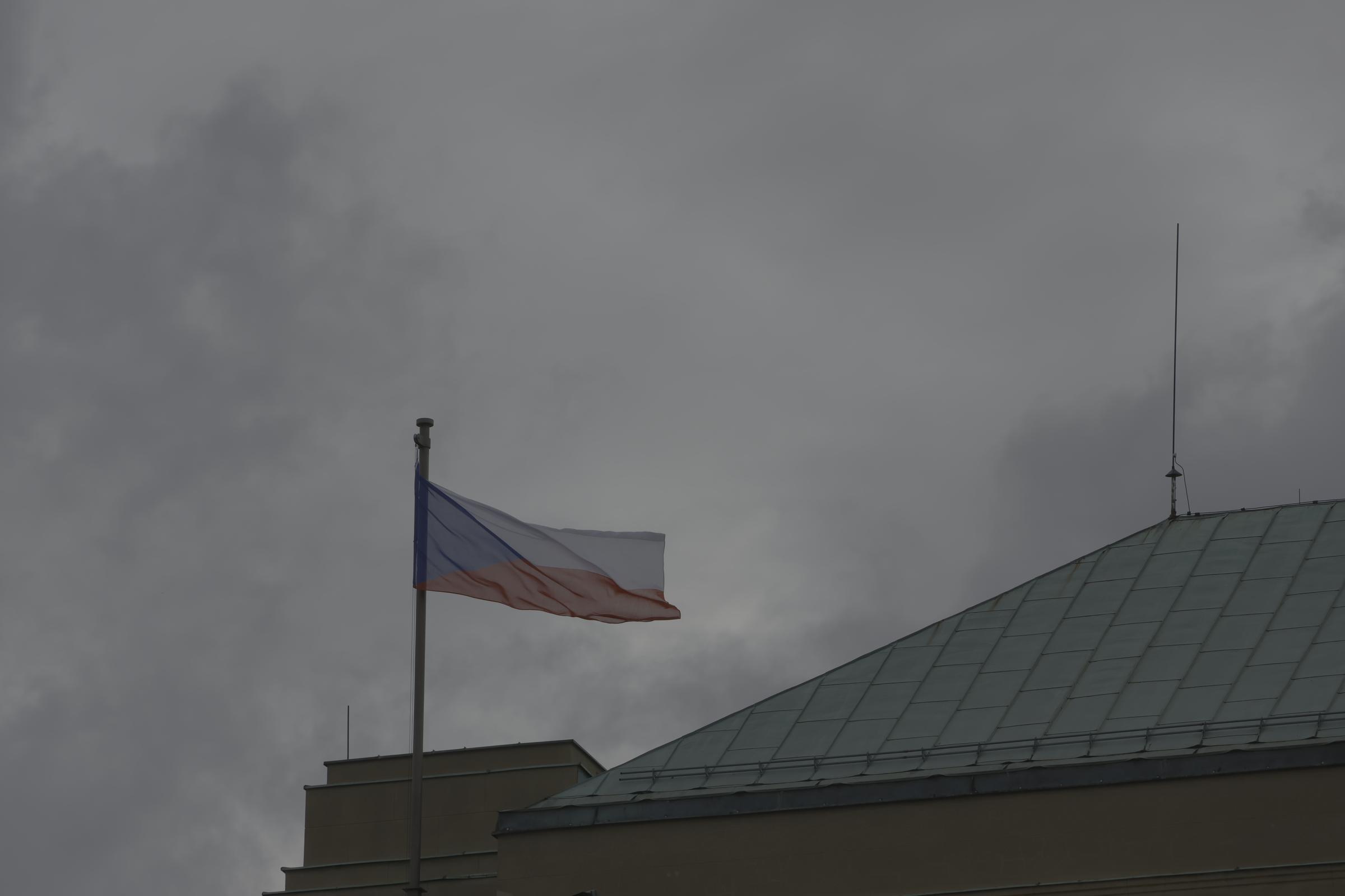 Drapeau et toiture urbaine devant un ciel nuageux